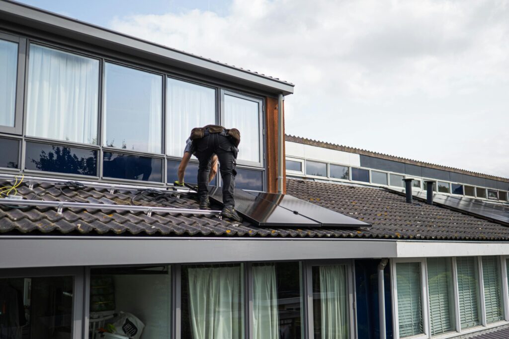 A solar technician performing maintenance on rooftop solar panels to ensure long-term efficiency.