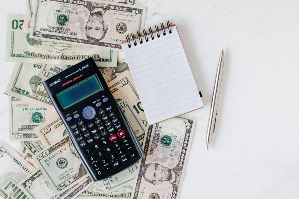 A calculator, notepad, and cash representing energy bill savings.