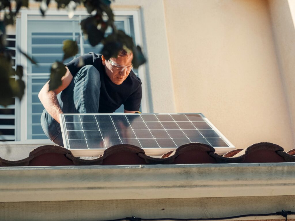 Solar company in Los Angeles – professional installer securing a solar panel on a residential rooftop.