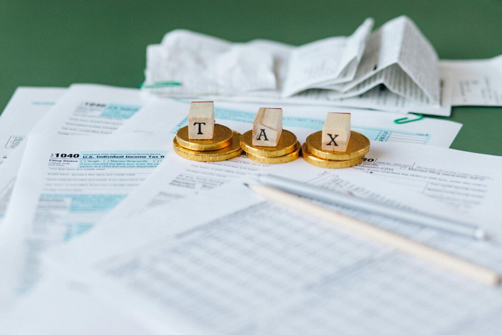 A stack of tax documents with gold coins symbolizing solar tax incentives.