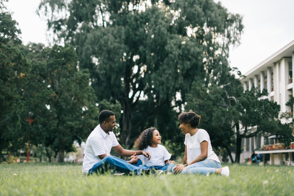 A happy family relaxing outdoors in a green park.