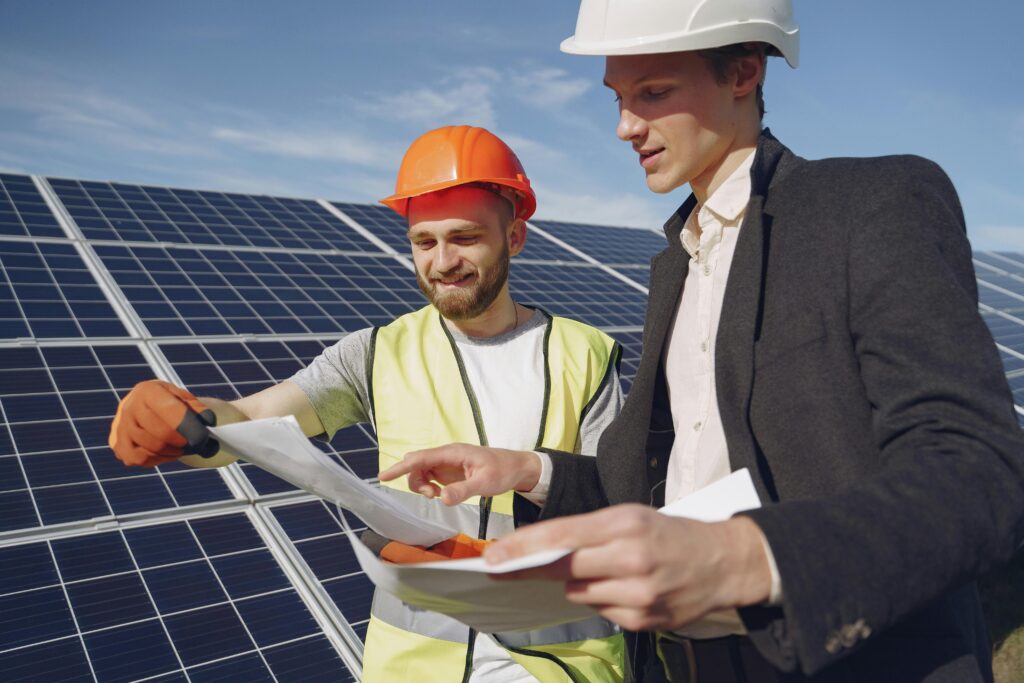 Expert solar panel installation in Los Angeles – two engineers reviewing plans in front of installed solar panels.